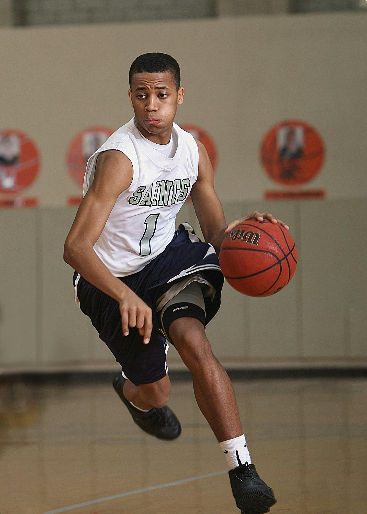 Energetic basketball player in mid-dribble on an indoor court.