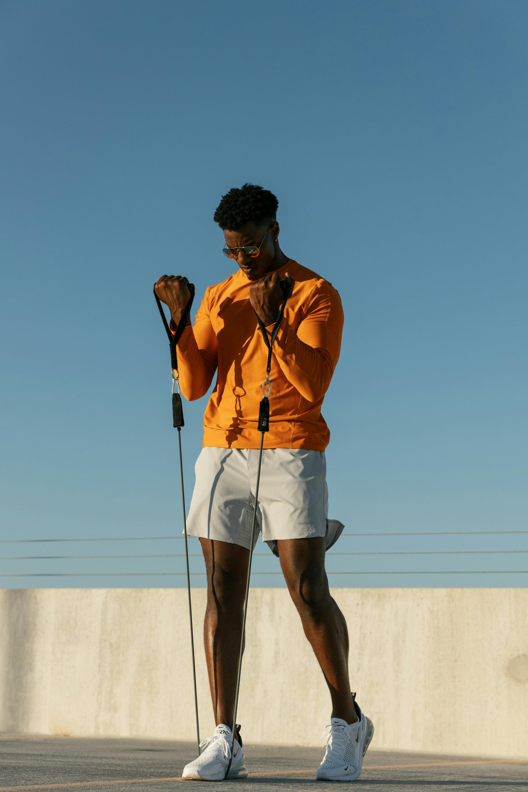 A man performs exercises with resistance bands on a sunny rooftop in Austin, Texas.